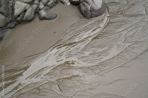 Water washing over sandy beach and rocks.