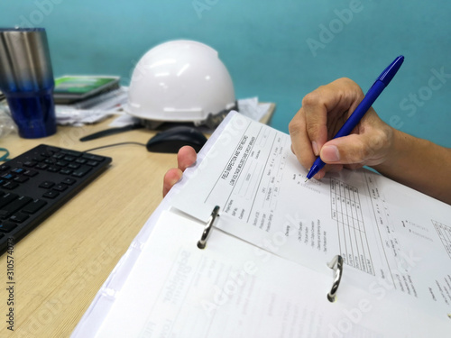 Engineer inspecting and checking datasheet.Engineers check the preventive maintenance documents after the operation.	