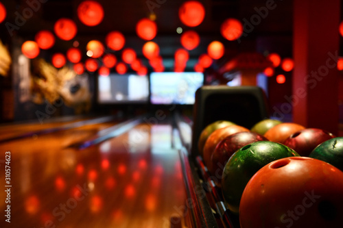 Bowling lane and balls in the row in bowling center.