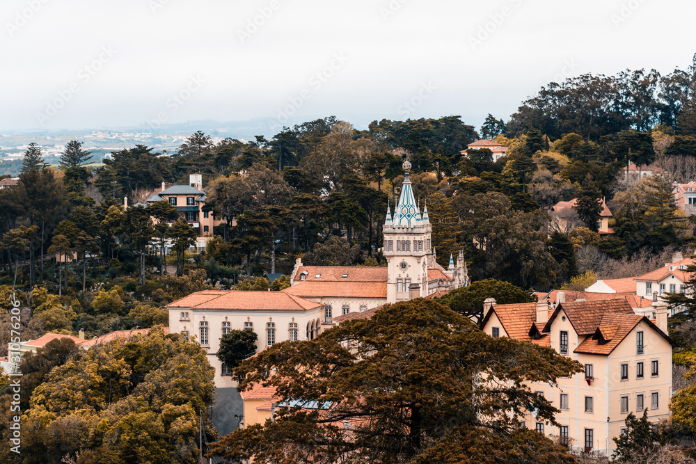 Scenic view to the center of the town Sintra in Portugal with the many old medieval historical buildings. Panoramic day city view. Roofs between the trees. Red tiling tops.