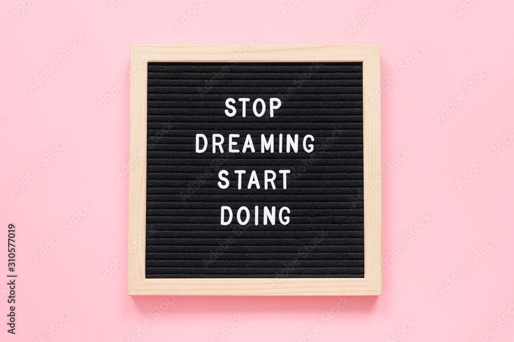 Fototapeta Stop Dreaming Start Doing. Motivational quote on letterboard on pink background. Top view Flat lay Concept inspirational quote of the day