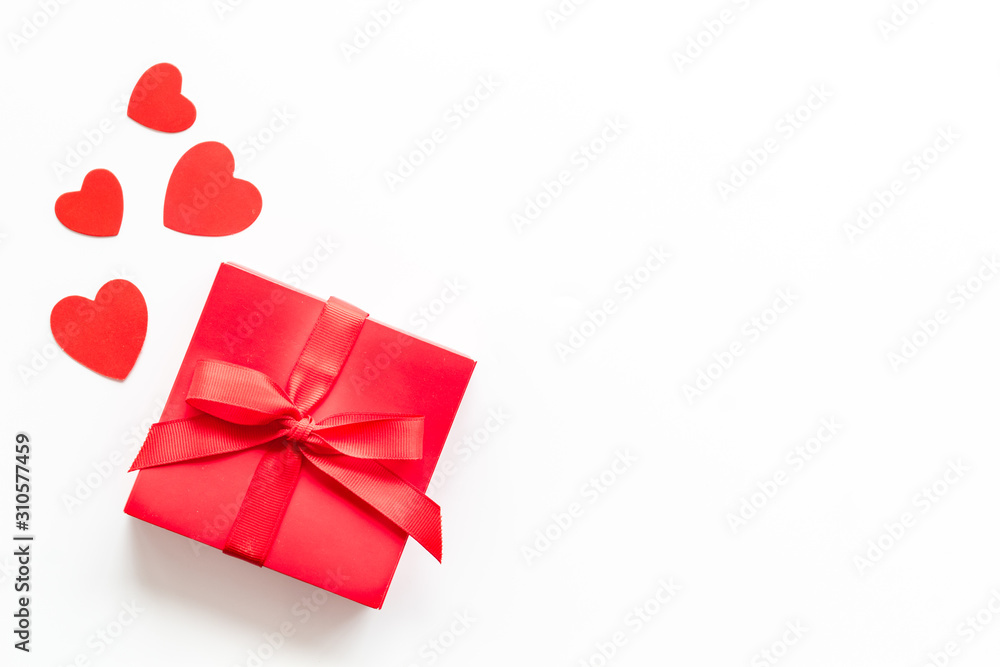 Gift to a sweetheart on Valentine's Day. Red present box near hearts on white background top-down copy space Gift to a sweetheart on Valentine's Day. Red present box near hearts on white background top-down copy space
