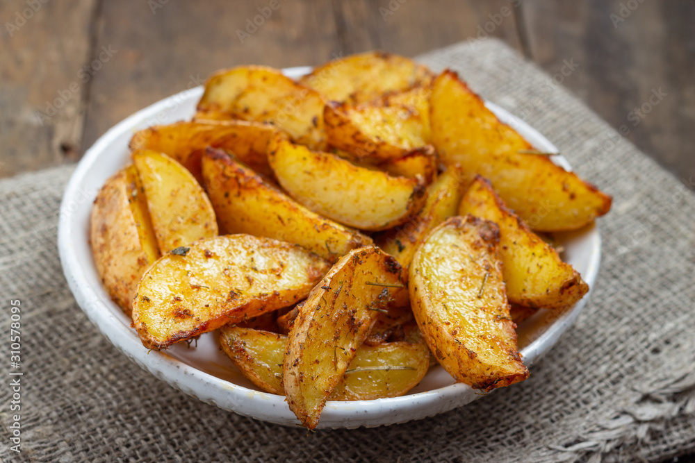 Baked potato with spices in a plate on the rustic table. Baked potato with spices in a plate on the rustic table.