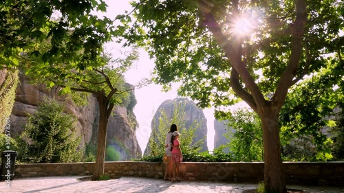 young woman and teenage girl admire the marvelous mountains of Meteora, Greece, at sunset. wonderful landscape.
