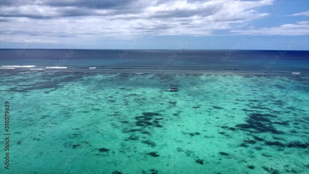 Slow aerial dolly shot of boat riding across crystal clear indian ocean Slow aerial dolly shot of boat riding across crystal clear indian ocean