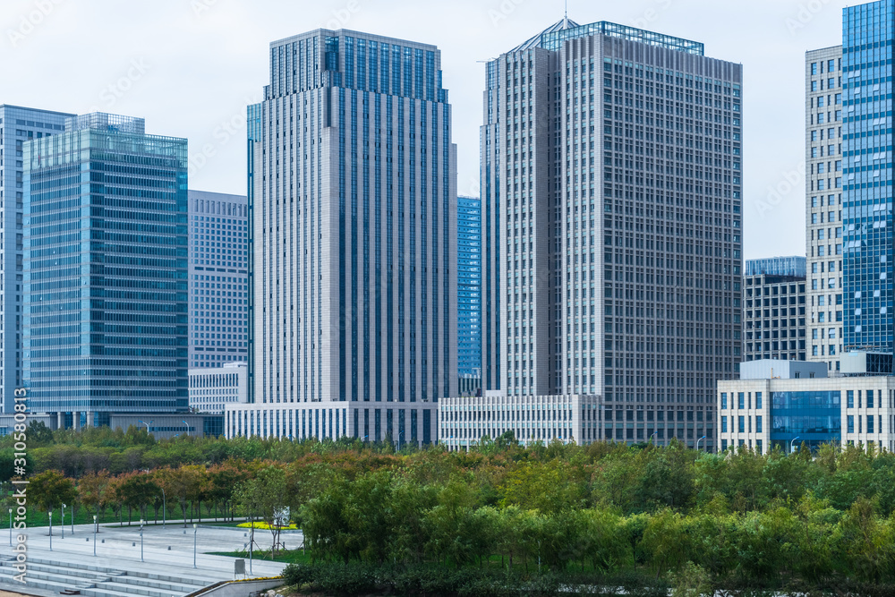 green trees front of modern glass office building green trees front of modern glass office building