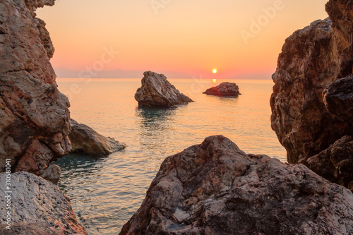 dawn on the rocky shore of the sea big rocks and a rock by the water