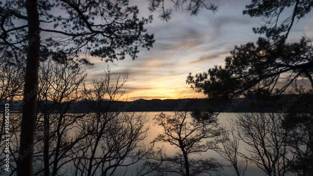 Sunset Time Lapse video of Lake Obertrum in Salzburg in early winter shot from Mt. Wartstein in town Mattsee. Colour changing from golden to blue hour with beautiful reflections on the water. Sunset Time Lapse video of Lake Obertrum in Salzburg in early winter shot from Mt. Wartstein in town Mattsee. Colour changing from golden to blue hour with beautiful reflections on the water.