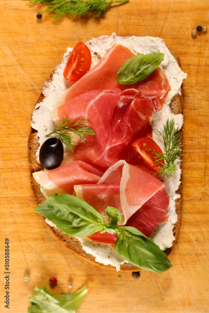 bread slice with cream, prosciutto ham and basil bread slice with cream, prosciutto ham and basil