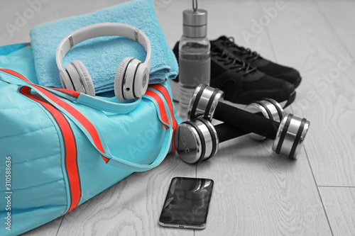 Foto Sports bag and gym stuff on wooden floor