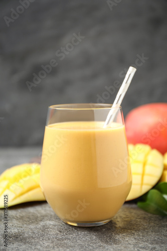 Fresh delicious mango drink on grey table