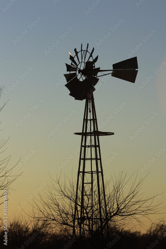 silhouette of windmill at sunset with sky in Kansas. silhouette of windmill at sunset with sky in Kansas.