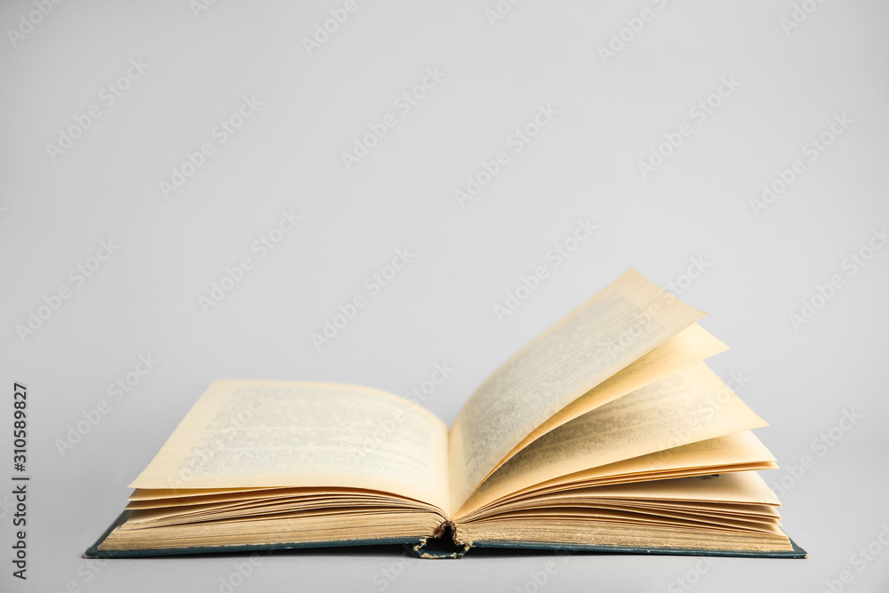 Obraz premium Open old hardcover book on light grey background. Space for text