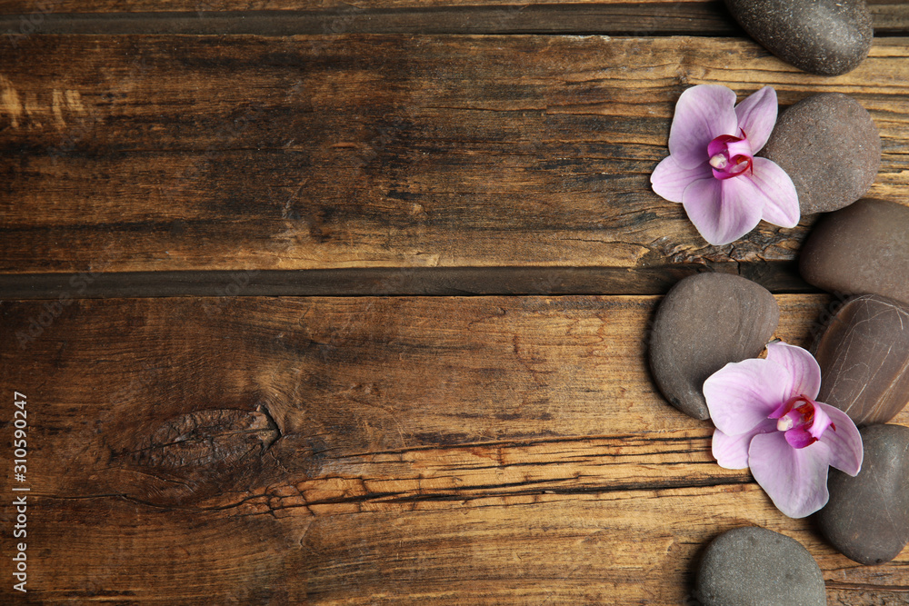 Stones with orchid flowers and space for text on wooden background, flat lay. Zen lifestyle Stones with orchid flowers and space for text on wooden background, flat lay. Zen lifestyle