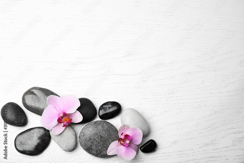 Stones with orchid flowers and space for text on white wooden background, flat lay. Zen lifestyle Stones with orchid flowers and space for text on white wooden background, flat lay. Zen lifestyle