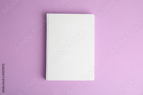Book with blank cover on violet background, top view © New Africa