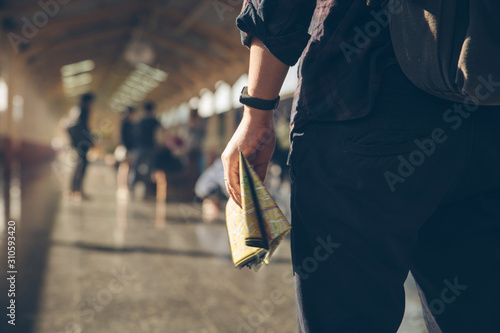 Tourist backpacker holding map standing at train station for travel. Travel concept
