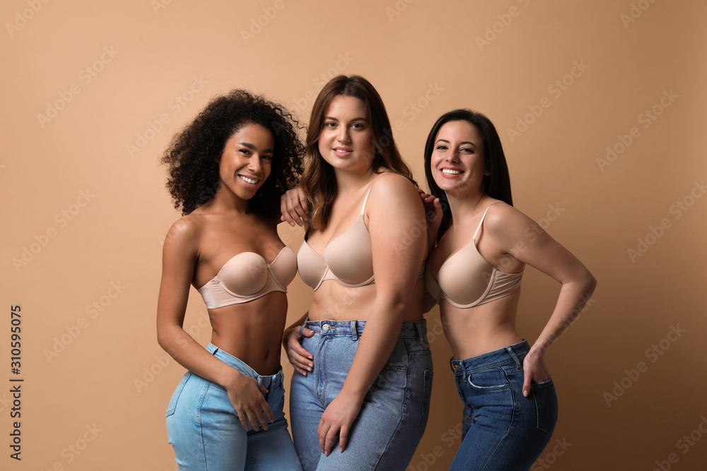 Foto de Group of women with different body types in jeans and underwear on  beige background do Stock