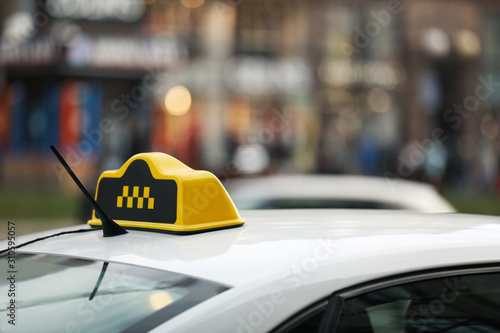Taxi cab with yellow sign on city street, closeup