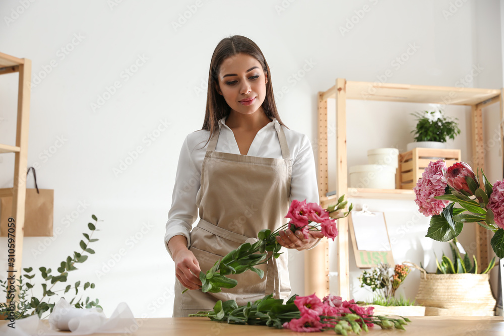 Florist making beautiful bouquet at table in workshop Florist making beautiful bouquet at table in workshop