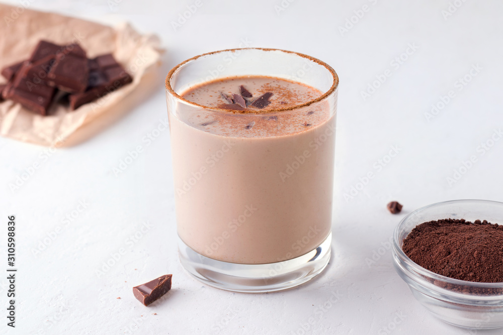 Lassi indian chocolate drink next to chocolate and cocoa on a white background Lassi indian chocolate drink next to chocolate and cocoa on a white background