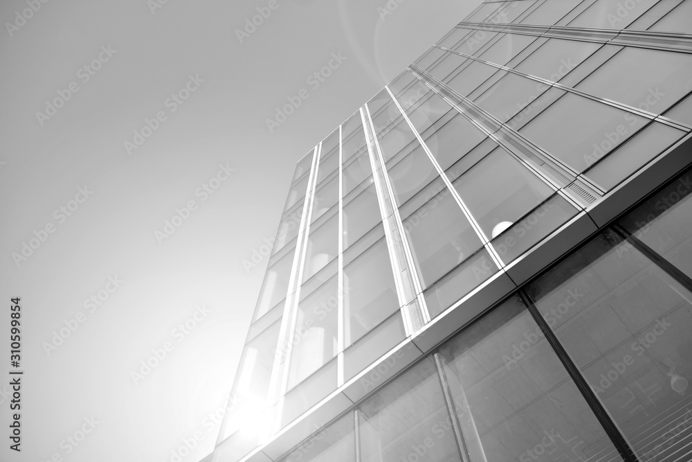 Sun rays light effects on urban buildings in sunset. Modern office building detail, glass surface with sunlight. Business background. Black and white. Sun rays light effects on urban buildings in sunset. Modern office building detail, glass surface with sunlight. Business background. Black and white.