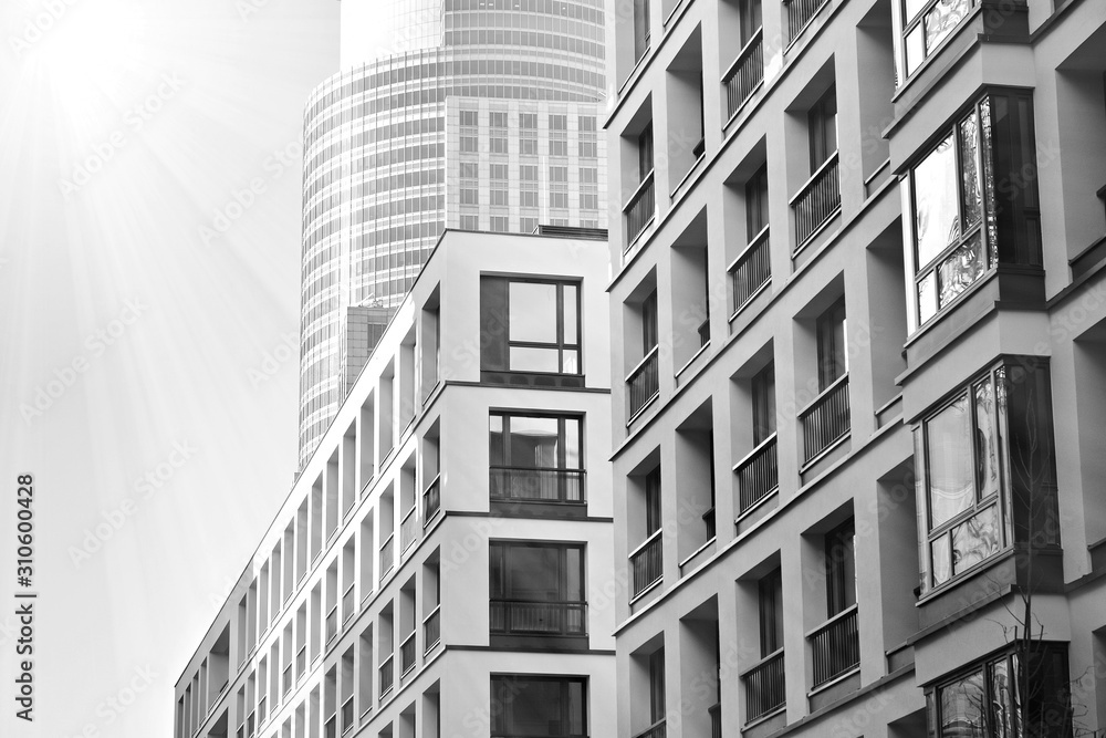 Sun rays light effects on urban buildings. Fragment of modern residential apartment with flat buildings exterior. Detail of new luxury house and home complex. Black and white. Sun rays light effects on urban buildings. Fragment of modern residential apartment with flat buildings exterior. Detail of new luxury house and home complex. Black and white.