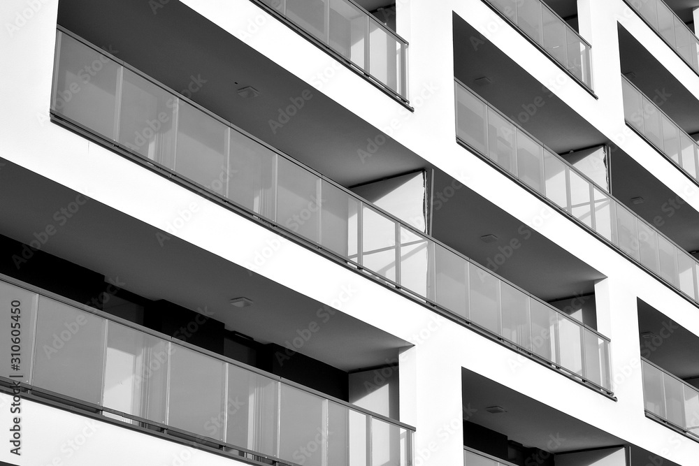 Obraz premium Sun rays light effects on urban buildings. Fragment of modern residential apartment with flat buildings exterior. Detail of new luxury house and home complex. Black and white.