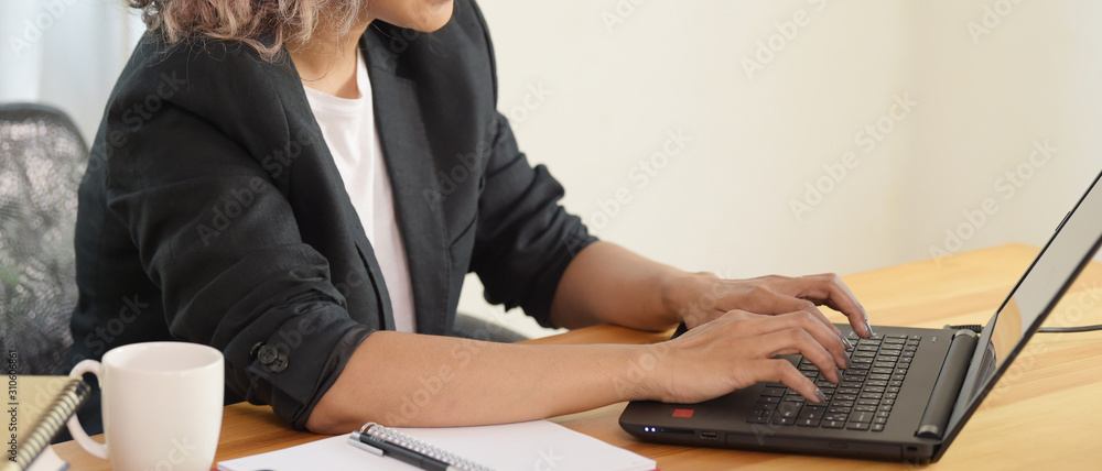 Portrait of female executive sitting at her desk in office Portrait of female executive sitting at her desk in office
