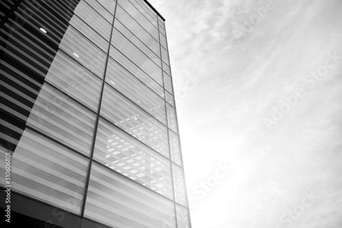 Sun rays light effects on urban buildings in sunset. Modern office building detail, glass surface with sunlight. Business background. Black and white.