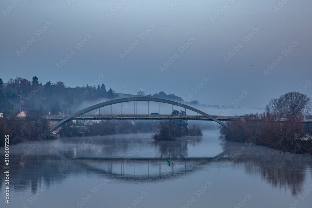 Naklejka premium Morgennebel um eine Brücke am Fluss