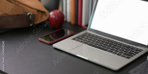 Cropped shot of modern workplace with mock up laptop computer and office supplies