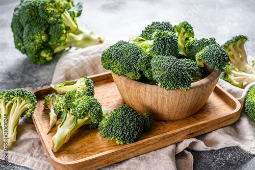 Fresh broccoli in a wooden bowl. Gray background. Top view