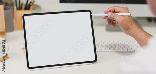 Close-up view of young man holding blank screen tablet