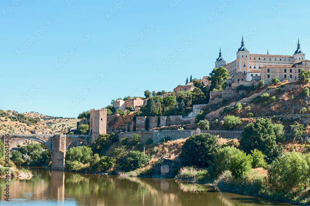 view from the river bank on the fortress wall and castles of the ancient Spanish city of Toledo