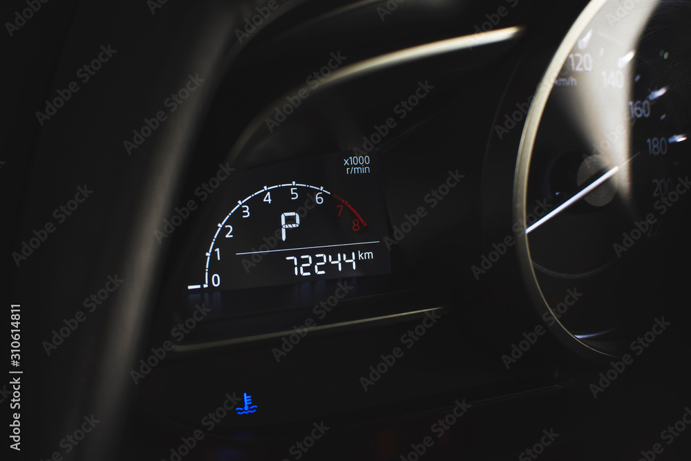 Rpm digital gauge and temperature warning light and parking position of automatic transmission and odometer on digital display dashboard in a luxury car.
