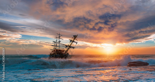 Tableau sur toile Old ship sailing in front of the sunset
