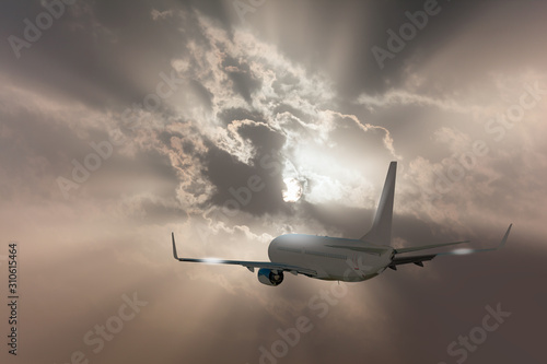 White plane flying to grey clouds