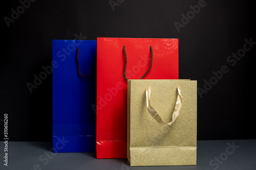 Close up of three color Shopping bag isolated on black background. Packaging template mockup. Delivery concept advertising mock. Shopping Concept