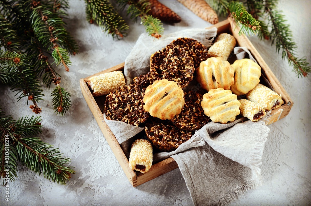 Mix of Christmas cookies in a wooden box on a gray background with Christmas decorations Mix of Christmas cookies in a wooden box on a gray background with Christmas decorations