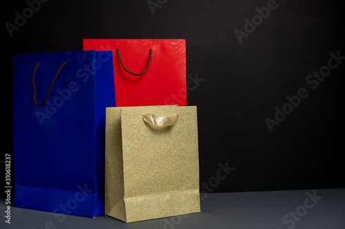Three color paper Shopping bag isolated on black background. Packaging template mockup. Delivery concept advertising mock. Shopping Concept