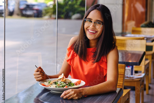 Young latinamerican girl eat a healty salad in restaurant