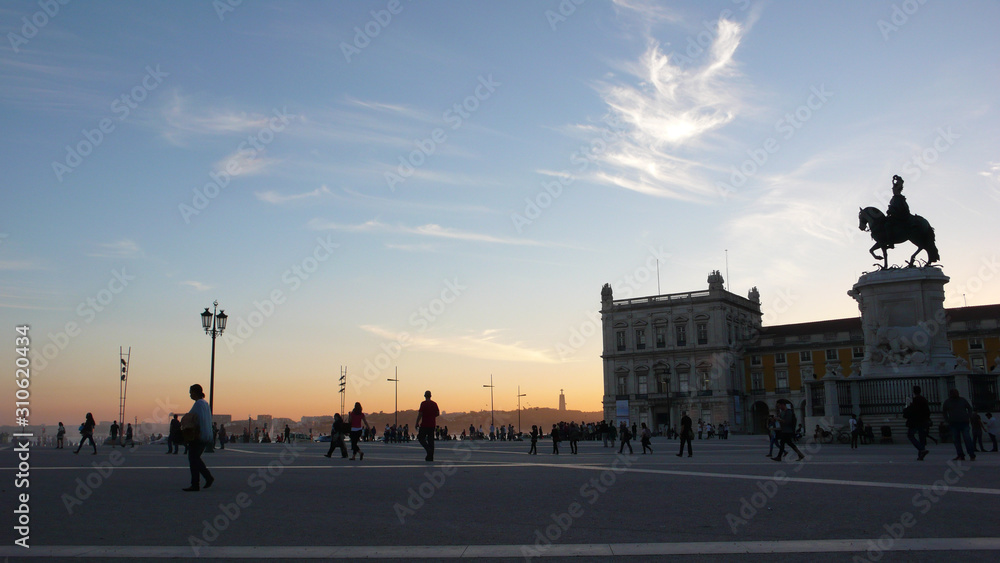 the famous Praca de Comercio Square in the heart of Lisbon at sunset with many pedestrians