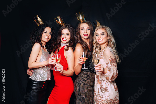 Group of young attractive women celebrating a party, drinking champagne and dancing.