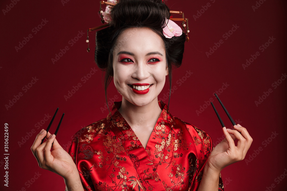 Obraz premium Image of beautiful geisha woman in japanese kimono holding chopsticks