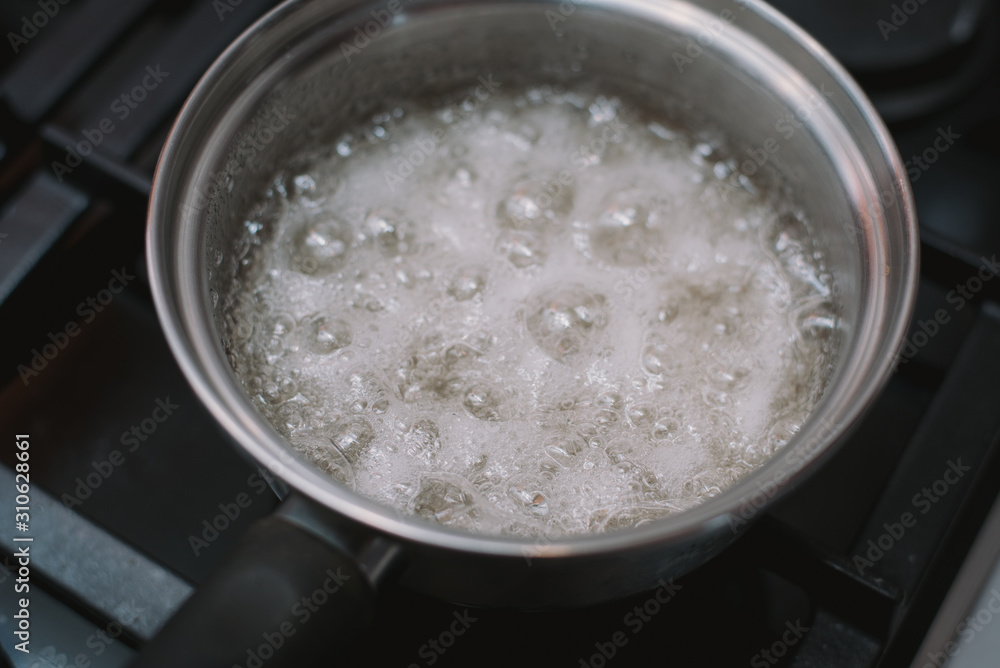 Boiling and boiling water and sugar in a pan on the stove. Cooking salted caramel at home. The recipe for homemade caramel and burnt sugar Boiling and boiling water and sugar in a pan on the stove. Cooking salted caramel at home. The recipe for homemade caramel and burnt sugar