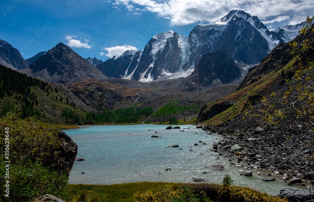 Mountain lake on the background of snow-capped peaks in the Altai Republic.