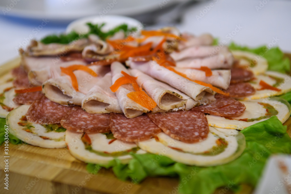 Sliced smoked bacon and sausage. Cold food appetizer on the table. Sliced smoked bacon and sausage. Cold food appetizer on the table.