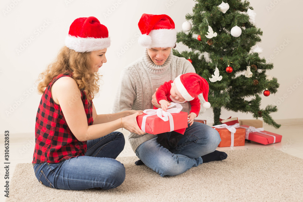 Happy couple with baby celebrating Christmas together at home. Happy couple with baby celebrating Christmas together at home.
