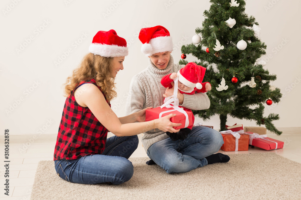 Happy couple with baby celebrating Christmas together at home. Happy couple with baby celebrating Christmas together at home.